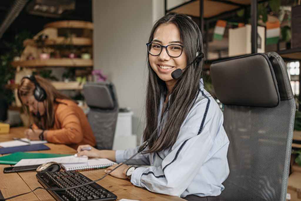 a woman smiling while sitting on her workspace