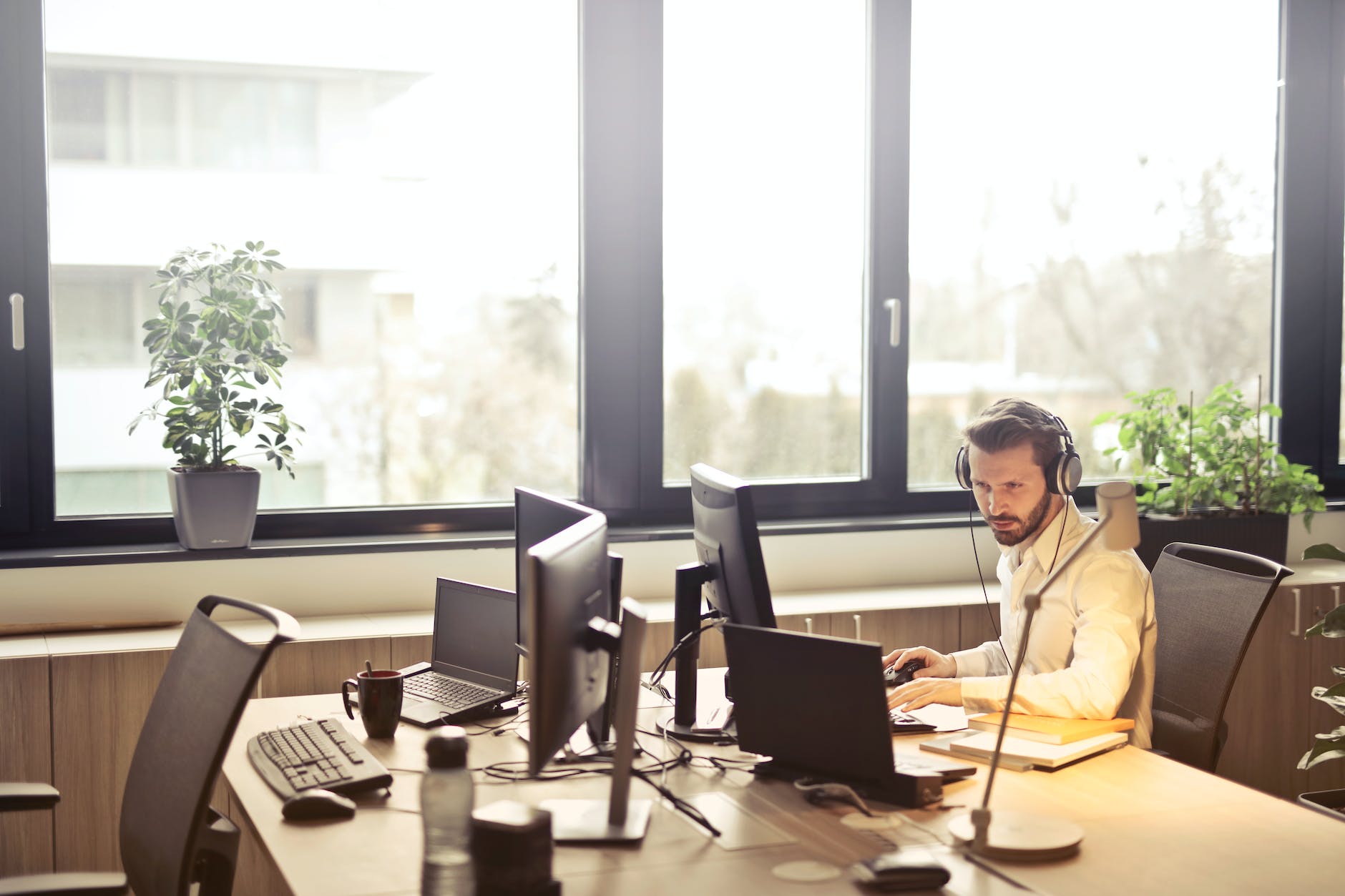 Man met headset aan het werk op zijn desktop