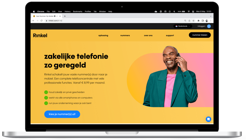 Een laptop met een kleurrijke website over zakelijke telefonie, gepresenteerd met een man die een telefoon vasthoudt en een vrolijke uitstraling heeft.